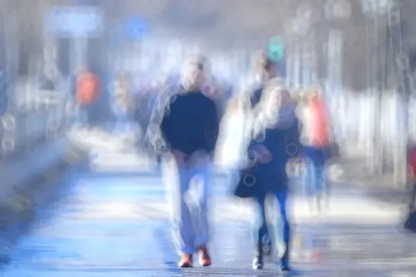 Blurry image of people walking on a street.